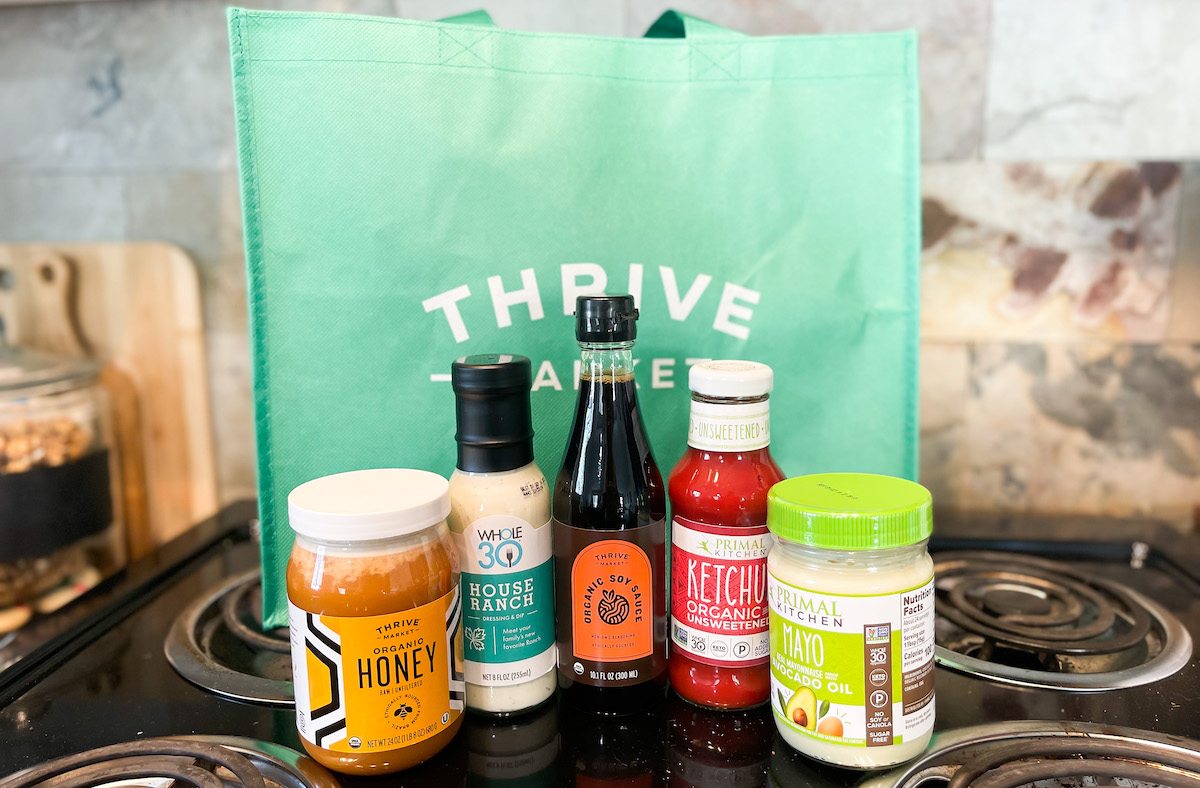 bottles of condiments with thrive market bag on stovetop