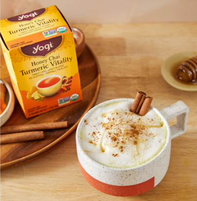 Honey Golden Milk Latte sits on a counter next to a carton of Honey Chai Turmeric Vitality