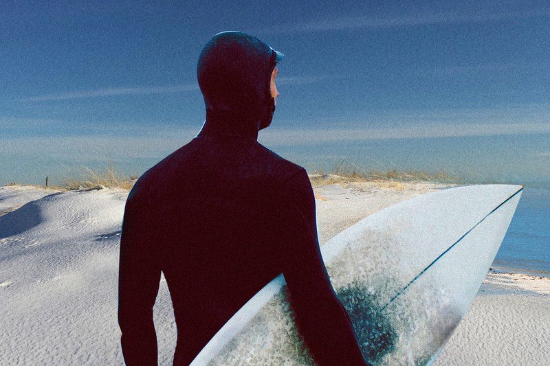 Guy in surf a suit on a winter beach