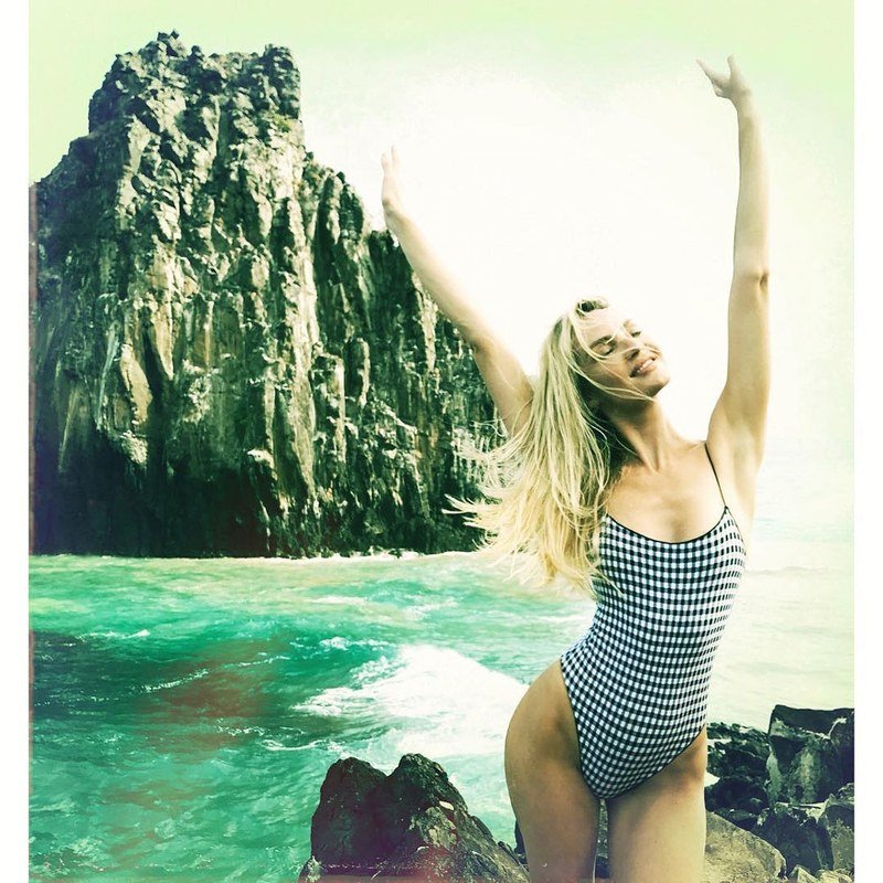 Candice Swanepoel pairs surf-sprayed blonde with a scenic backdrop.