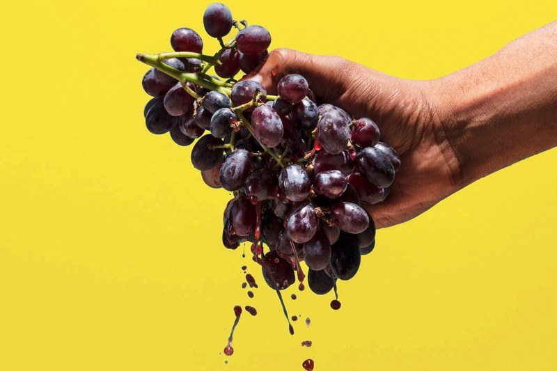 hand squeezing grapes