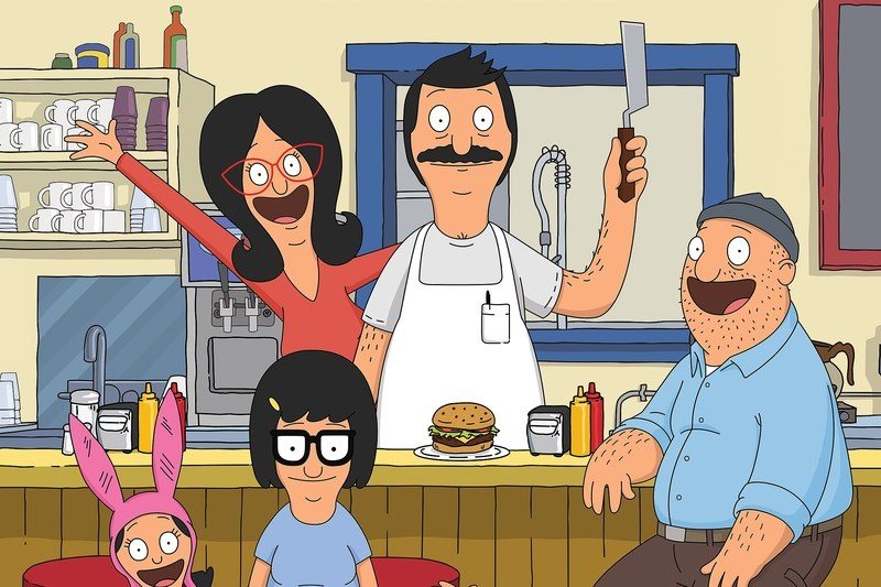 The main cartoon characters of Bob's Burgers smiling and posing at their restaurant