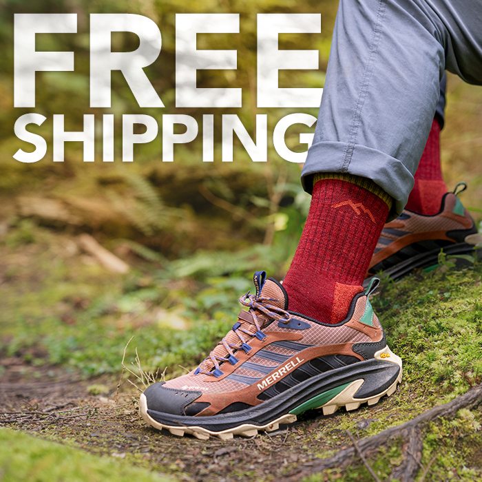 Shop with Free Shipping - a hiker on a mossy trail shows off their cranberry red Darn Tough socks.