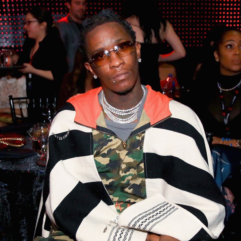 Young Thug in a striped jacket and a camo shirt.