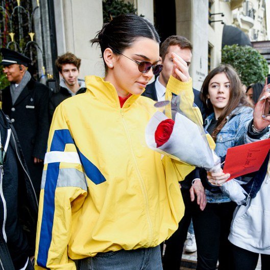 Kendall Jenner pairs a center-parted low knot with sunglasses.