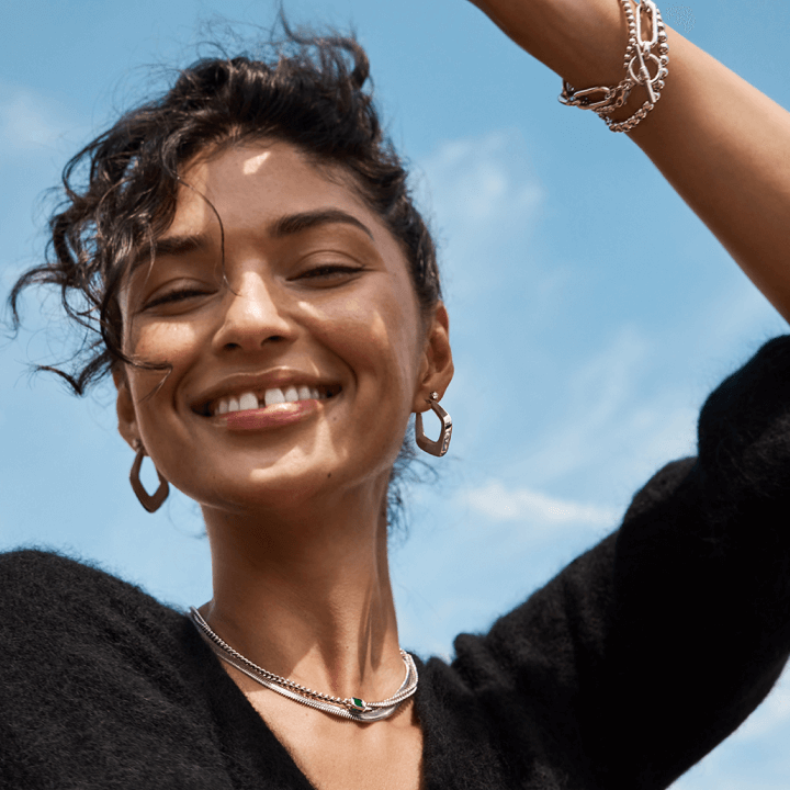 Women dancing smiling and wearing necklace , bracelet and earrings