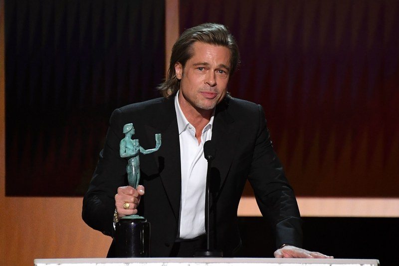 Image may contain: Brad Pitt, Suit, Coat, Clothing, Overcoat, Apparel, Human, Crowd, and Person