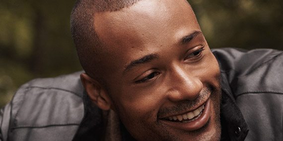 Smiling man wearing jewelry and a watch