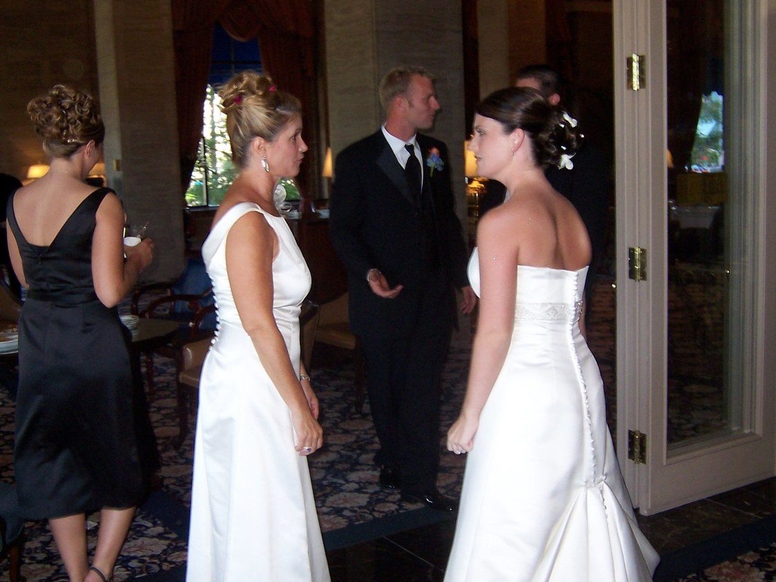 two women in white wedding gowns