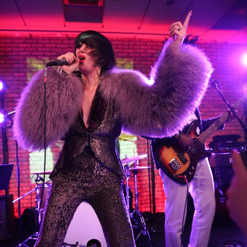 Karen O in big puffy sleeves onstage.