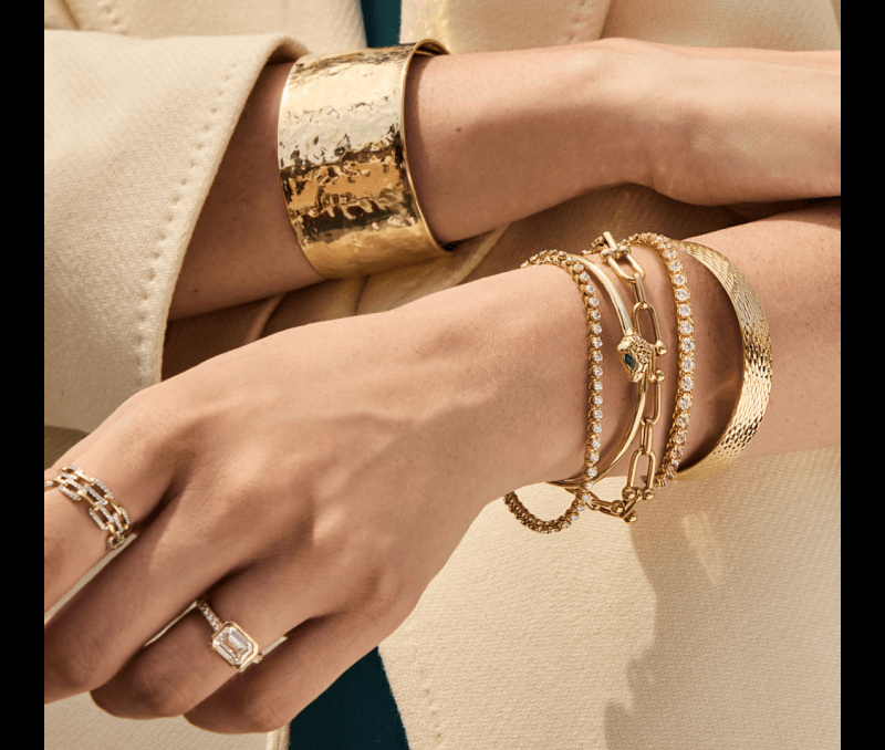 A woman’s hand showcasing beautiful Gold Jewelry - Bracelets, Rings.