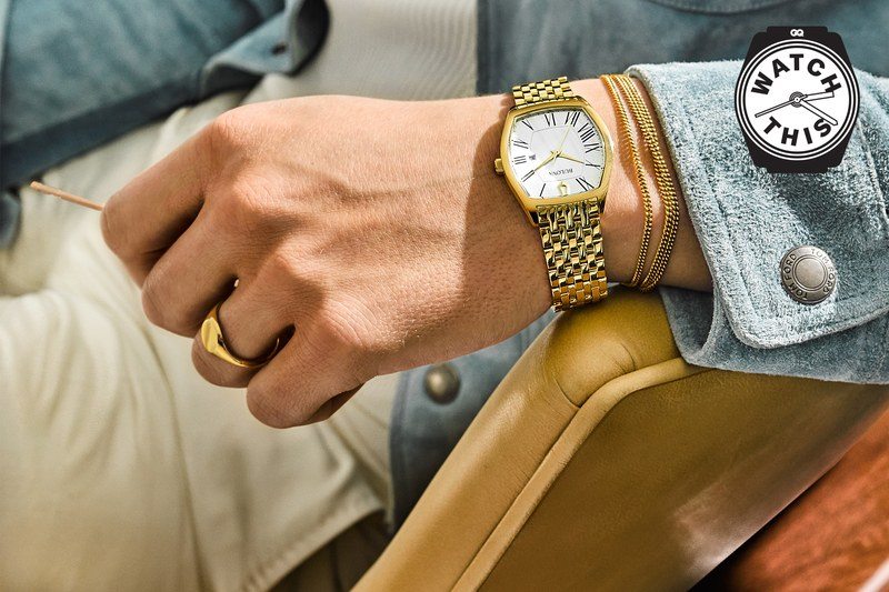 Closeup photo of a small gold watch on a mans wrist