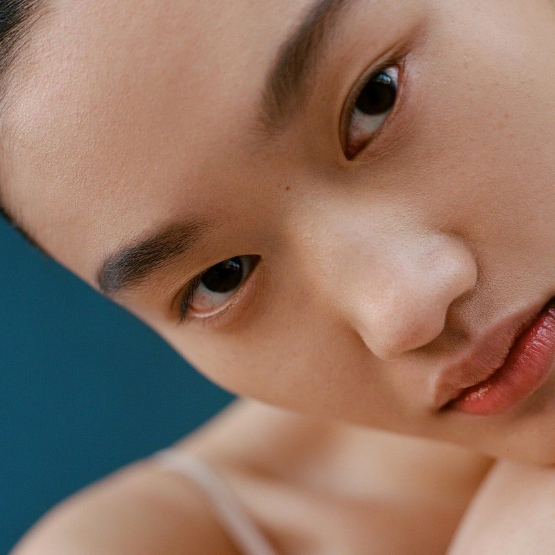 close-up, side shot of an asian model with bare skin and dark brows