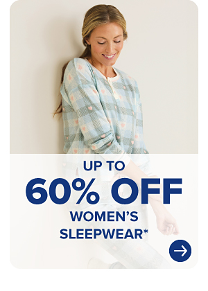 A woman in a plaid pajama shirt. Up to 60% off women's sleepwear.