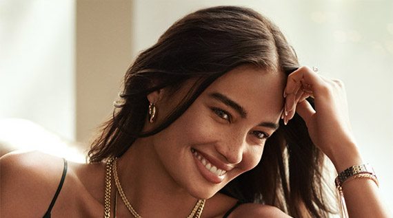 Happy woman wearing gold jewelry