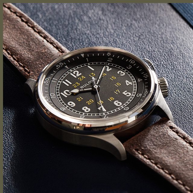 Close-up of stainless steel A-15 Pilot watch with black dial and top-stitch brown leather straps