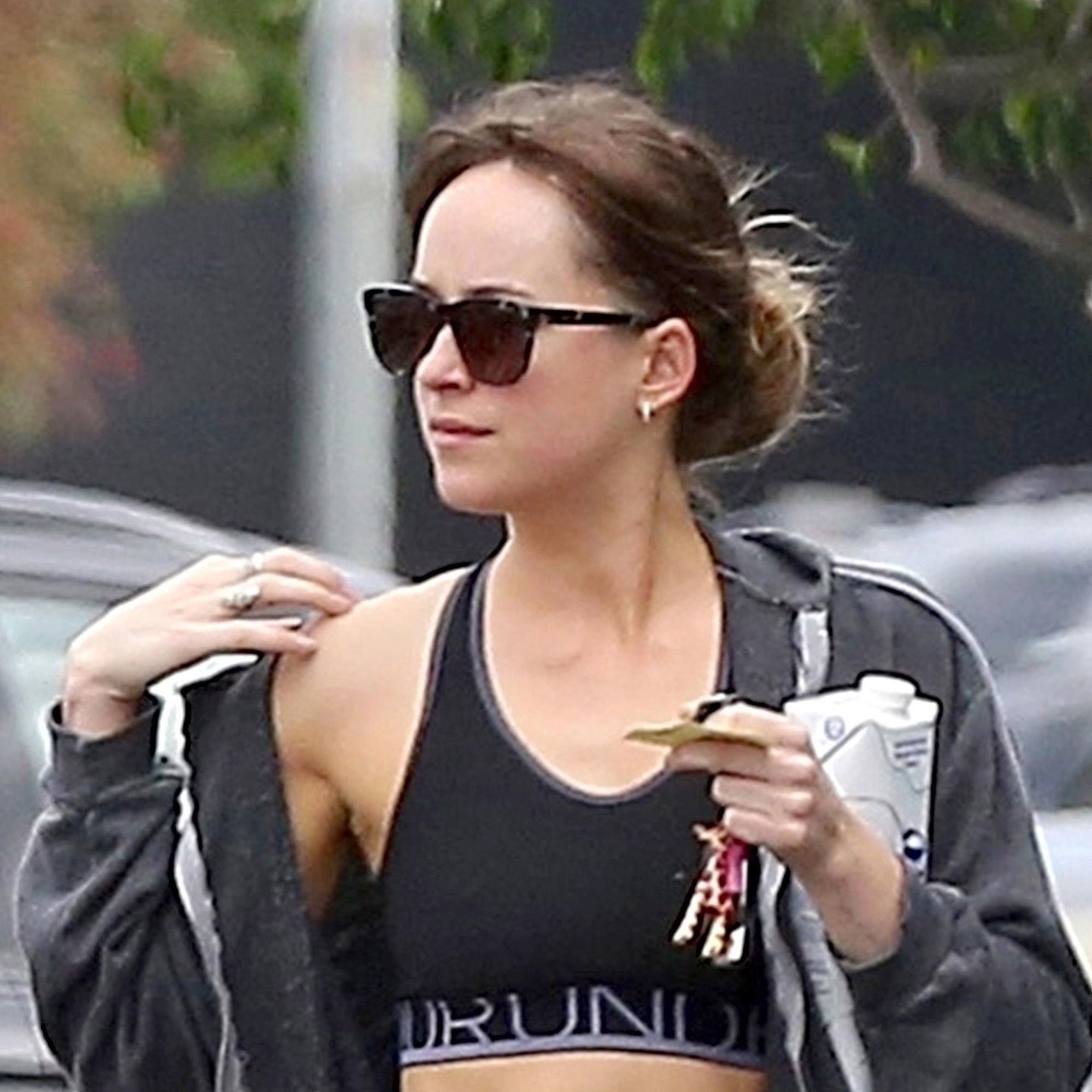 Dakota Johnson pairs an easy bun with a set of shades.