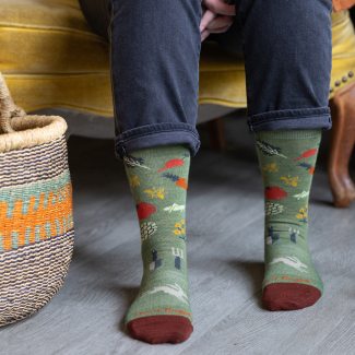 Shop Socks that benefit the VT Foodbank - a woman wearing green socks featuring vegetables