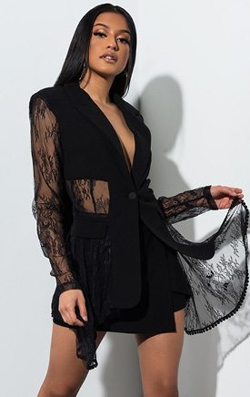 La Femme Fatale Lace Blazer Top is a sheer, fabric blocked top complete with sexy lace sleeves and a flowy hem detailing alongside a structured collar, padded shoulders, faux front chest pocket and a single button fasten.