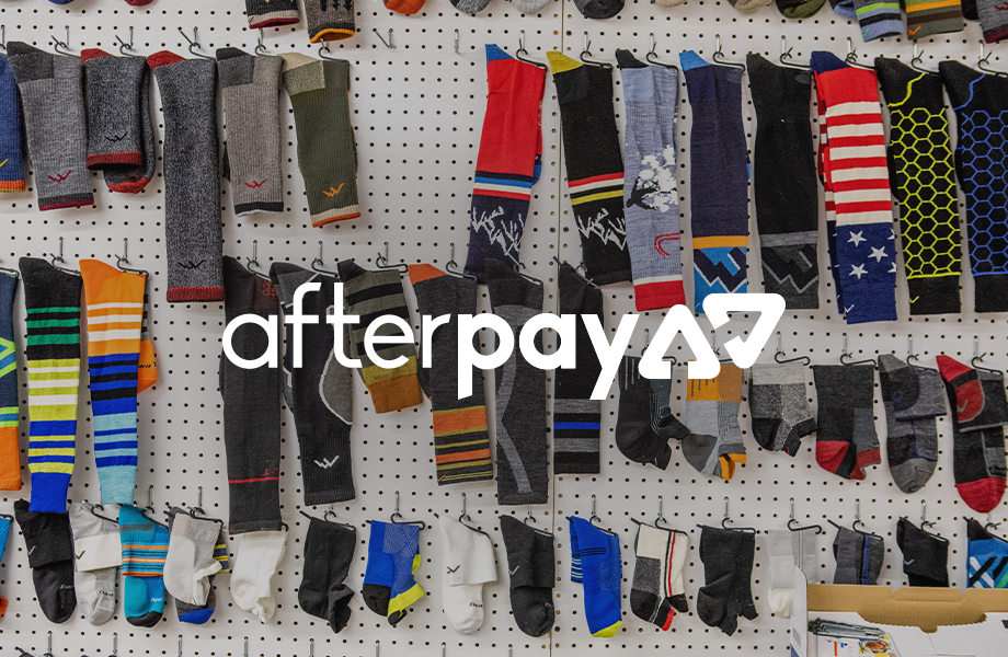 Afterpay logo imposing over a pegboard wall hanging our seriously-awesome socks