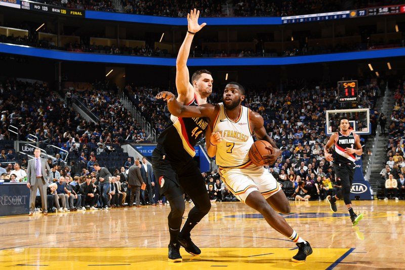 Eric Paschall of the Golden State Warriors handling the basketball against a player of the Portland Trail Blazers