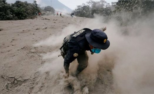 A police officer stumbles through pyroclastic deposits from the eruption | Reuters