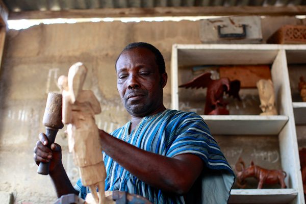 George Obeng carving a sculpture