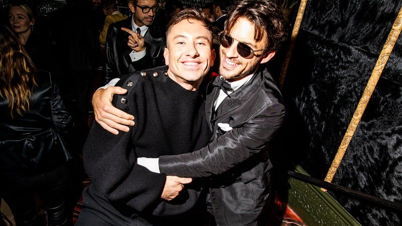 Image may contain: Jonathan Bailey, Clothing, Coat, Jacket, Adult, Person, Accessories, Glasses, and Photobombing