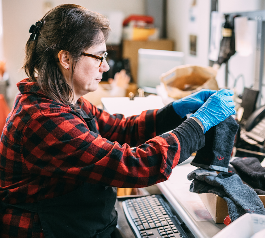 One of our Mill's quality checkers ensures a pair of socks is lifetime guaranteed quality status.