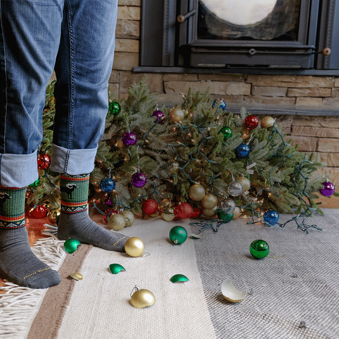 Shop with Free Shipping - feet wearing grey & green socks stand in front of the wreckage of a fallen Christmas tree