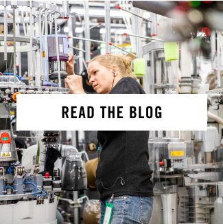 Read the blog - an employee works on a complicated knitting machine at the mill