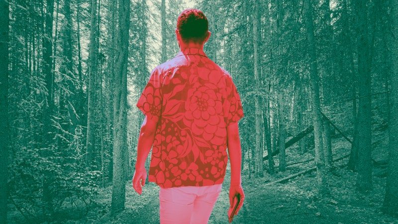 A stylish man walking through the woods
