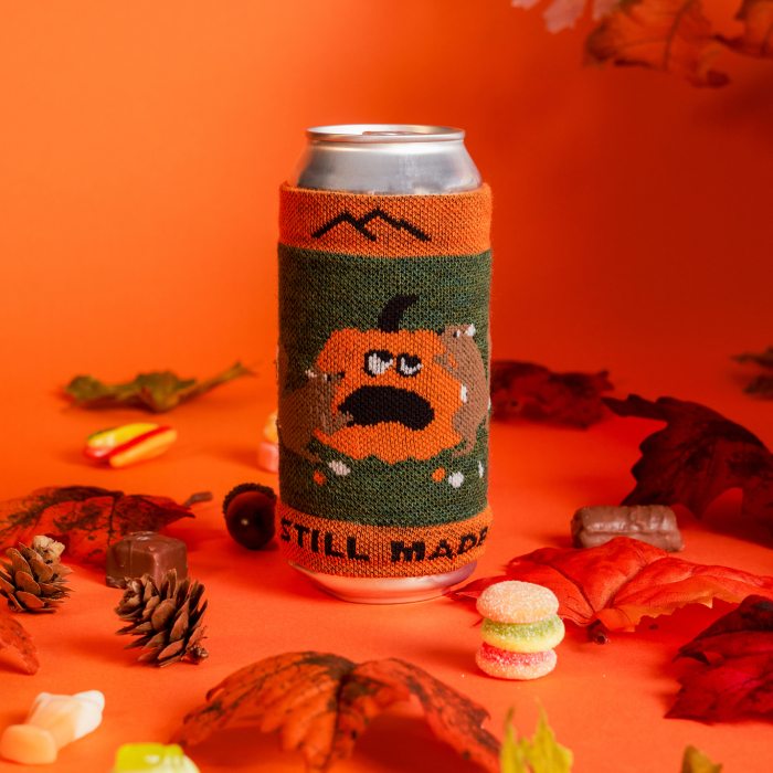 Shop Now - a knit can sleeve featuring mice on a jack-o-lantern, surrounded by leaves and halloween candy