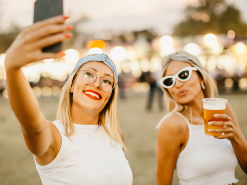 Two women taking a selfie at a festival.