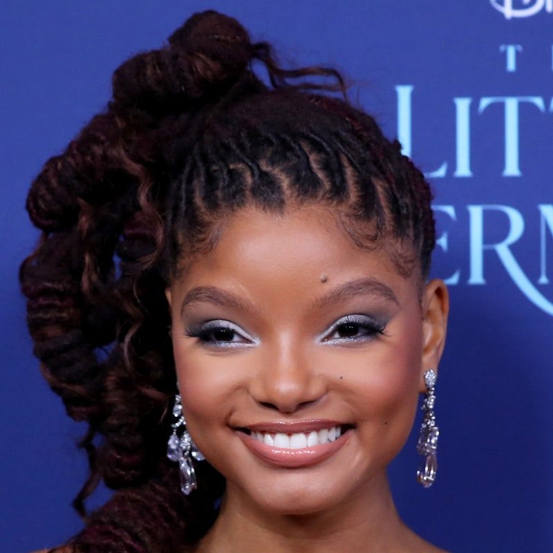 halle bailey smiling with elaborate twisted high loc ponytail 