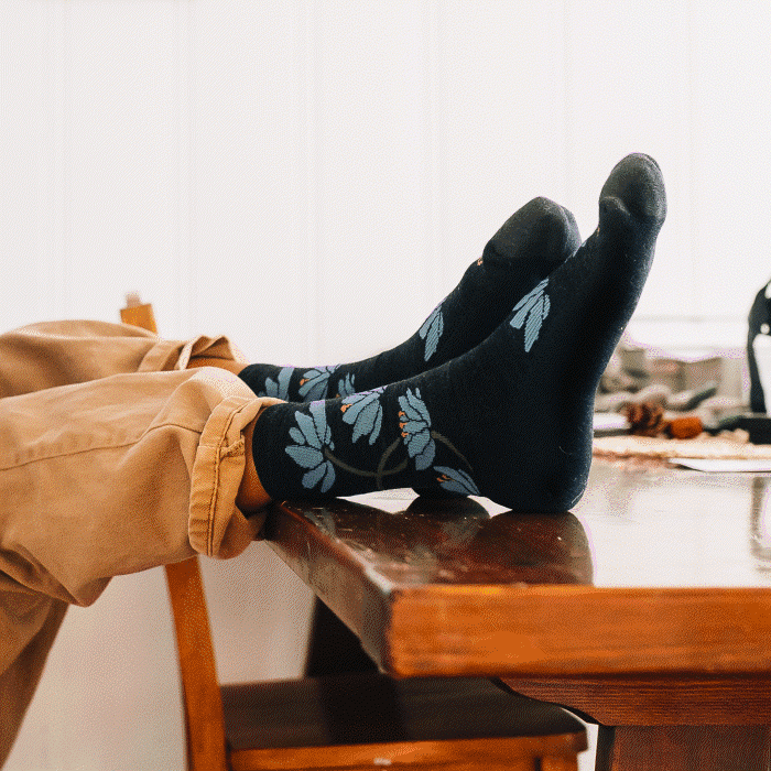 Feet wearing socks with beautiful nature designs, like leaves, clover, and sunflowers