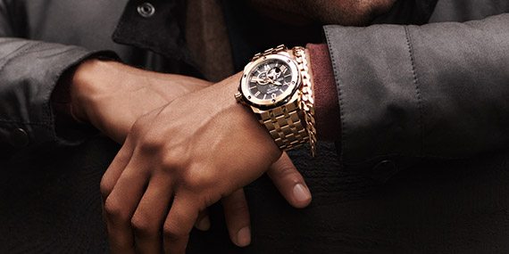 Smiling man wearing jewelry and a watch