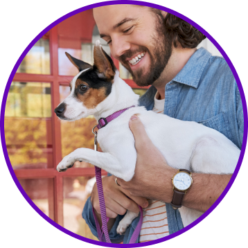 Circular vignette reveals a man holding a Jack Russell Terrier mix.