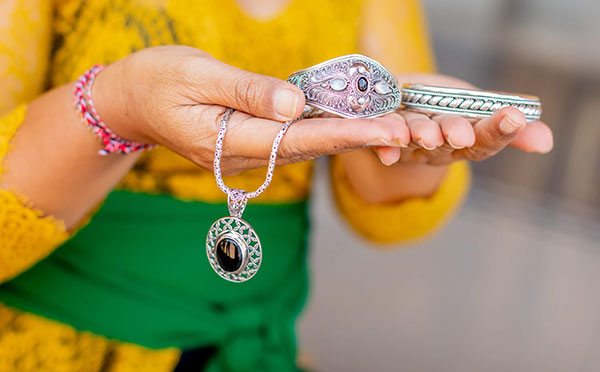 Picture of artisan holding jewelry