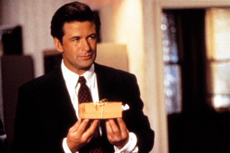 a man in a suit holding a gift on his fingertips