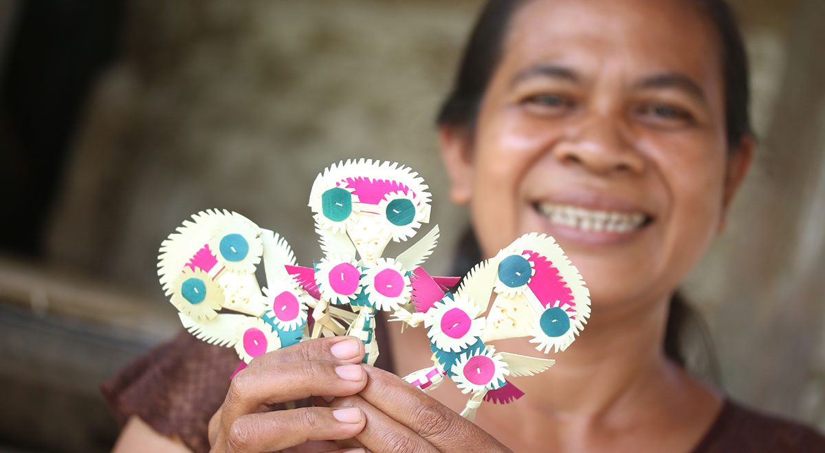 Kadek Suryati holds up the Cili dolls she just made