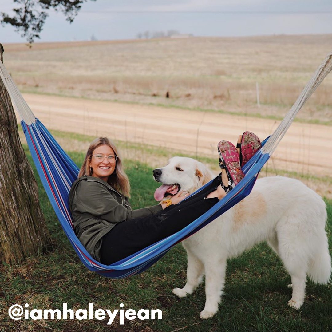 Sandals model hammocking by a road with fluffy golden retriever, social tag: @iamhaleyjean