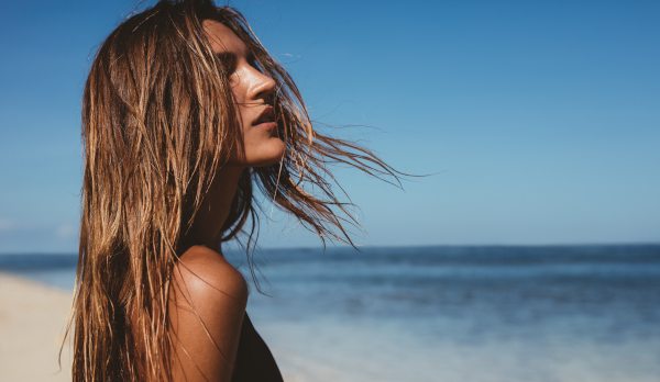 Woman on the beach with hair blowing in the wind