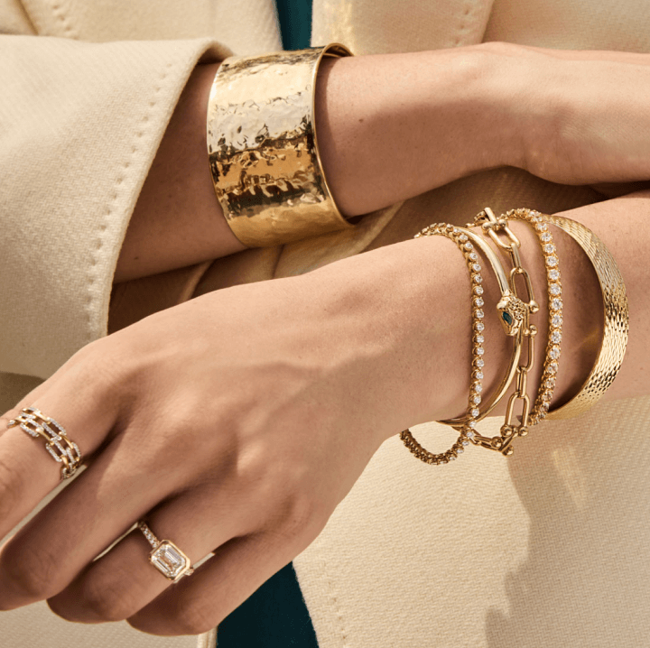 A woman adorned with a wide variety of stunning 10k & 14k golden jewelry.