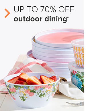 A white bowl and saucer with floral accents. Up to 70% off outdoor dining.