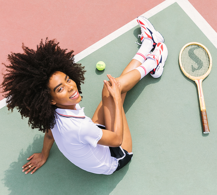 This young woman is all smiles while sitting on the tennis court in all-pro socks