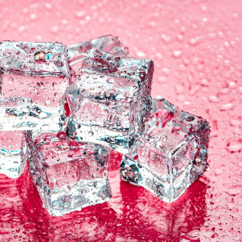 Pile of ice cubes on pink background