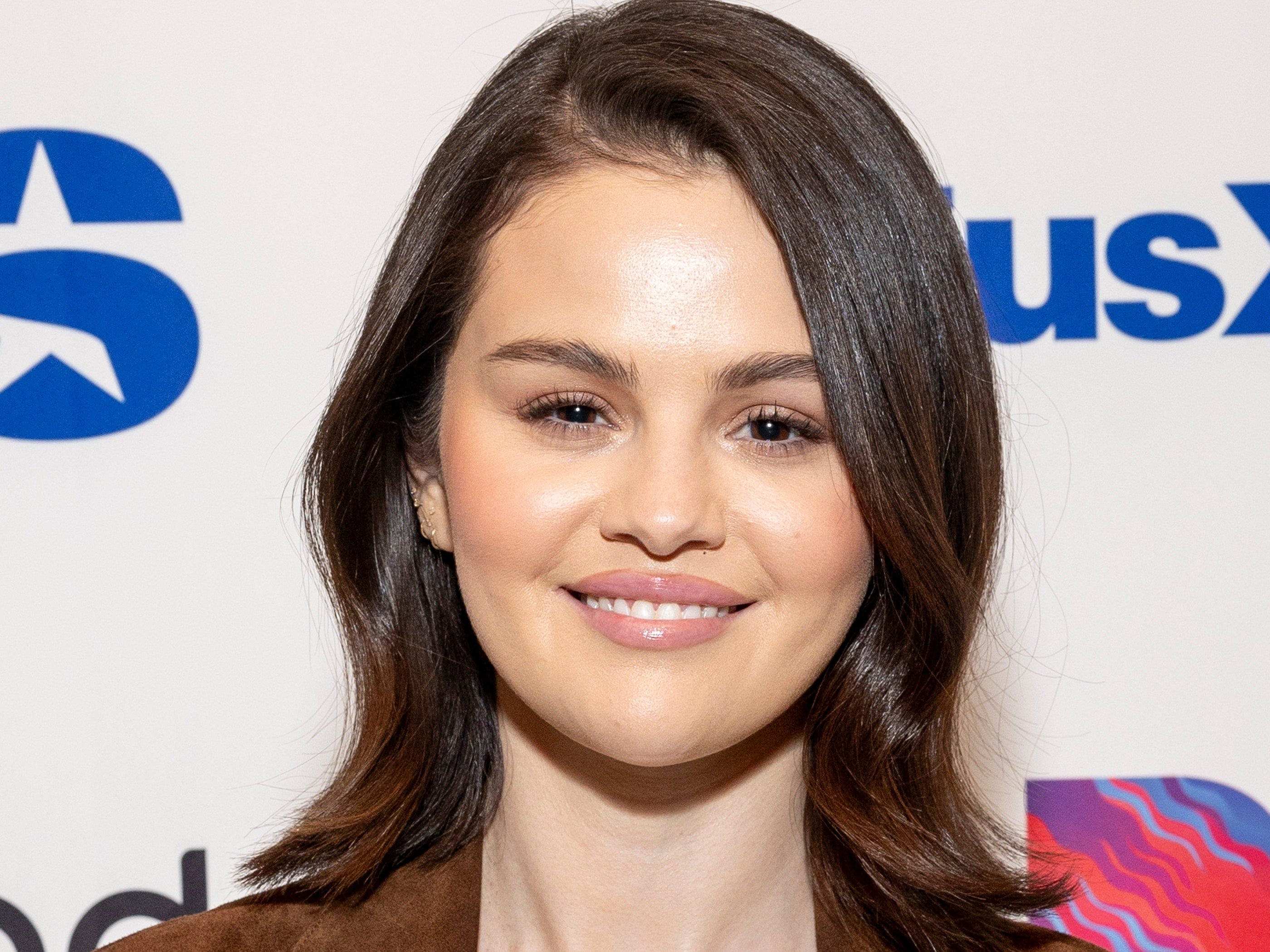 Image may contain: Selena Gomez, Head, Person, Face, Dimples, Adult, Happy, Smile, Photography, Portrait, Clothing, and Coat