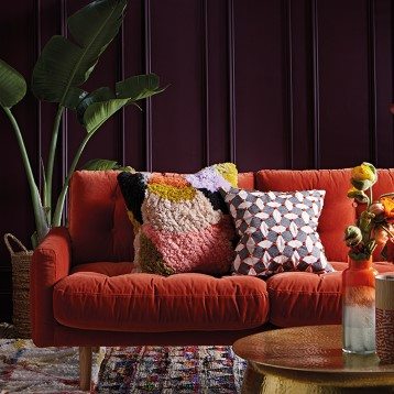 Orange velvet sofa with statement cushions
