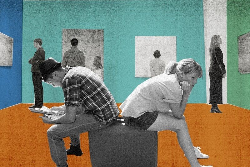 Couple at a museum sitting back to back